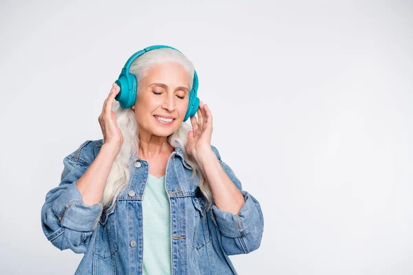 Porträt einer hübschen alten Dame, die die Augen schließt, berührt das Headset isoliert auf weißem Hintergrund — Stockfoto