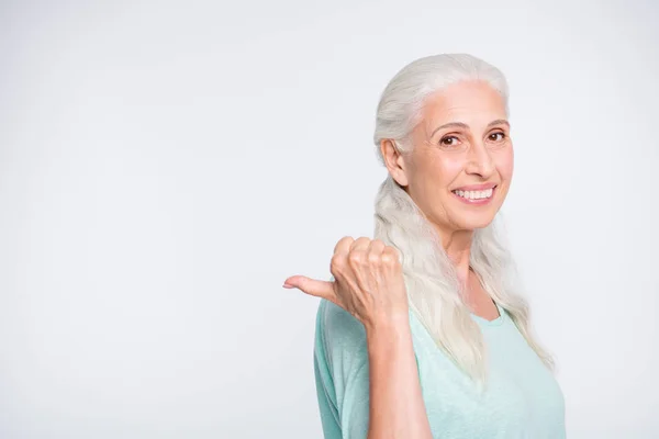 Portret van charmante persoon toont promotie met haar duim glimlachend dragen Turquoise Pullover trui geïsoleerd over witte achtergrond — Stockfoto