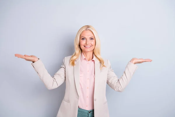 Porträtt av henne hon trevlig attraktiv charmig stilfull tillitsfull glad munter vågig-haired Lady visande hållande på Handflatta två osynlig syfte isolerad på ljus vitt grå pastell bakgrunden — Stockfoto