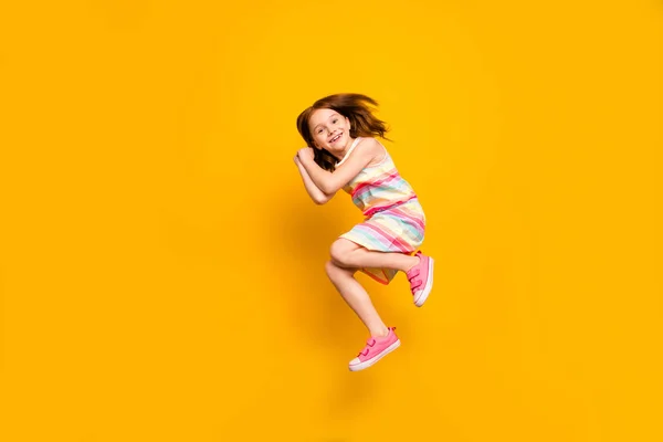 Фотография милой милой девушки в полный рост, прыгающей на желтом фоне — стоковое фото