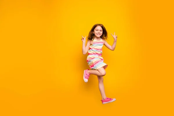 Foto em tamanho completo de criança alegre pulando fazendo v-sinais isolados sobre fundo amarelo — Fotografia de Stock