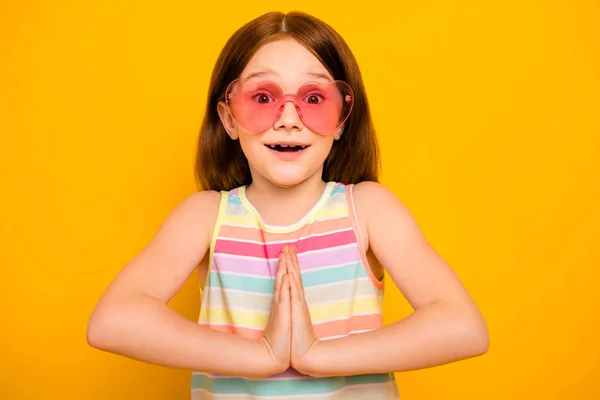 Retrato de menina bonito vestindo óculos em forma de coração tanque-top gritando wow omg isolado sobre fundo amarelo — Fotografia de Stock