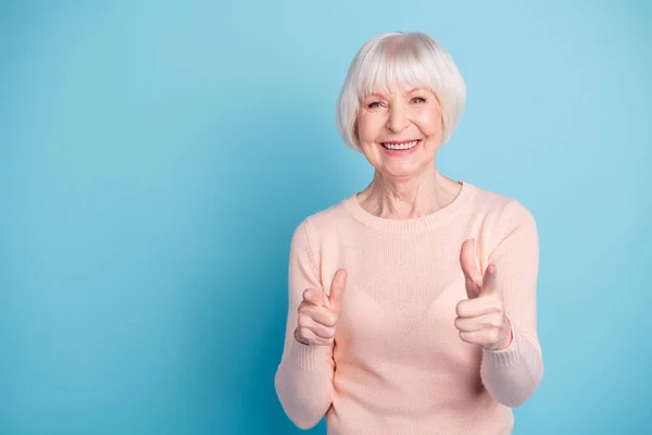 Retrato de vovó funky apontando sorrindo vestindo camisola pastel rosa isolado sobre fundo azul — Fotografia de Stock