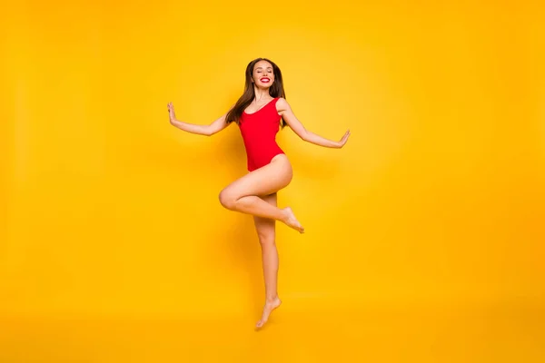 Полноразмерная фотография потрясающей смешной леди, красивой, веселой, прыгающей высоко в бассейн корпоративной вечеринки в красном купальнике на изолированном желтом фоне — стоковое фото