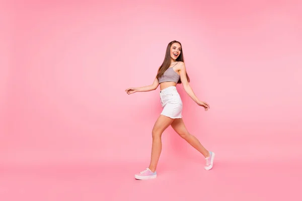 Foto de corpo inteiro de senhora bonito andando olhando vestindo camisas brancas tanque-top isolado sobre fundo rosa — Fotografia de Stock