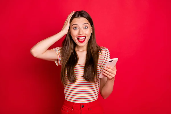 Foto de belo atraente encantador agradável alegre satisfeito senhora positiva segurando telefone inteligente em mãos tocando cabeça isolado fundo brilhante — Fotografia de Stock