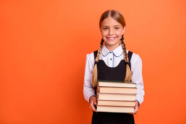 Porträtt av henne hon trevlig attraktiv tillitsfull glad glada smarta Smart blondin pre-Teen flicka innehav i händerna redovisade bok högen första klass isolerade över ljusa levande Shine orange bakgrund — Stockfoto