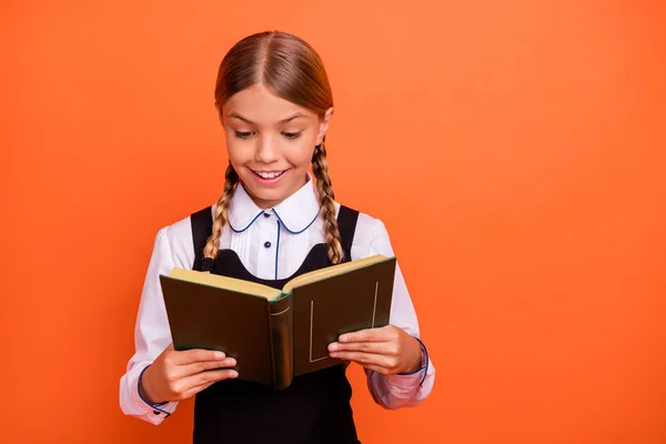 Close-up portret van haar ze mooie aantrekkelijke mooie vrolijke vrolijke Smart slimme intelligente pre-tiener meisje vasthouden in de hand interessant boek geïsoleerd over heldere levendige glans oranje achtergrond — Stockfoto