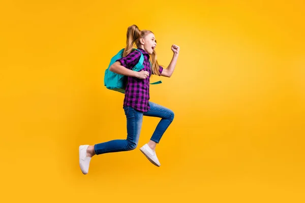 Ganzkörperseite Foto von kleinen Schüler springen hoch froh zurück Schule tragen lässig kariertes Hemd Jeans Jeans isoliert gelb Hintergrund — Stockfoto