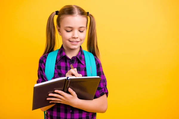 Primer plano de la foto de la pequeña dama diligente alumno notando palabras del profesor bloc de notas desgaste casual camisa a cuadros aislado fondo amarillo —  Fotos de Stock