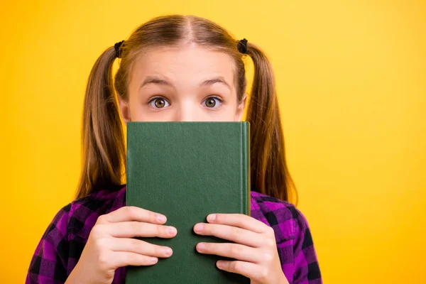 Close-up foto van Little Lady leerling houden boek verbergen half gezicht vrij paardenstaarten slijtage geruit overhemd geïsoleerd gele achtergrond — Stockfoto