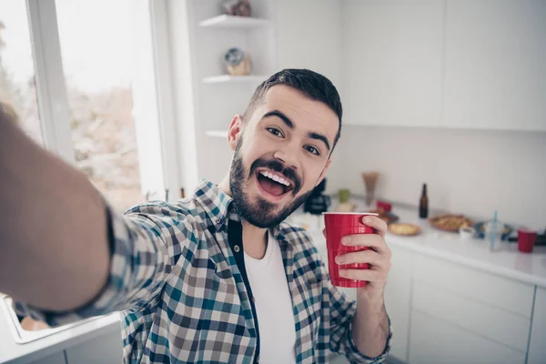 Autorretrato de su agradable atractivo alegre alegre divertido chico barbudo alegre con camisa a cuadros divertirse vacaciones en el interior blanco claro moderno estilo cocina interior interior — Foto de Stock