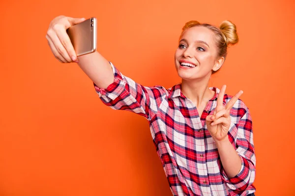 Close up photo beautiful nice she her her nice lady arm hand phone v-sign symbol excited rejoice toothy beaming smile say hi friends wear casual checkered plaid pink shirt isolated orange background —  Fotos de Stock