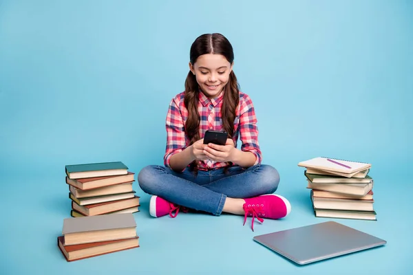 Retrato de ella que agradable chica alegre encantadora atractiva con camisa a cuadros sentado en pose de loto utilizando dispositivo gadget aislado sobre brillante brillante brillo azul fondo verde —  Fotos de Stock