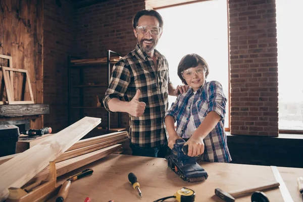 Retrato de dois agradável inteligente inteligente alegre criativo pessoa mestre pai filho antiquado profissão interessante ocupação mostrando thumbup no moderno loft industrial tijolo interior dentro de casa — Fotografia de Stock