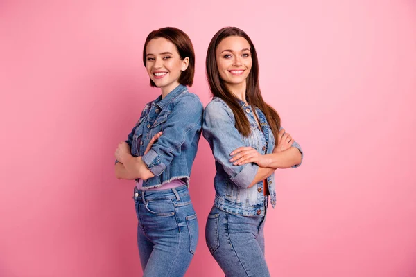 Close up side profile photo two beautiful she her ladies cool teamwork unity partners leaders arms crossed stand back fellowship wear jeans denim jackets blazers isolated bright pink background — Stock Photo, Image