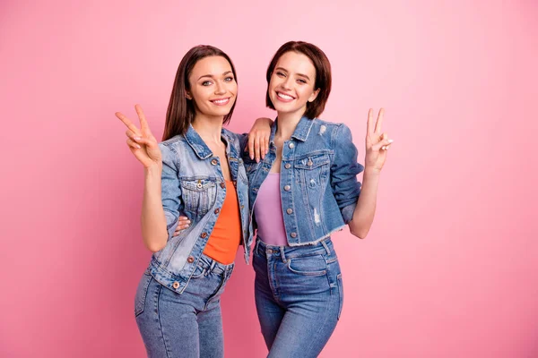 Close-up foto twee mooie funky zusters ze haar beste dames mooie verschijning partij chill Mood knuffelen v-teken symbool zeggen hallo hallo dragen jeans denim jassen Blazers geïsoleerd helder roze achtergrond — Stockfoto