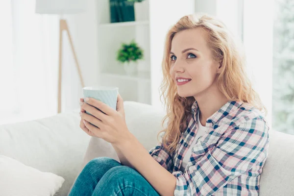 Retrato de cerca de ella ella bonita atractiva encantadora adorable alegre alegre tranquila chica de pelo ondulado en camisa a cuadros sentado en divan espresso en el estilo de luz blanca sala de estar interior — Foto de Stock