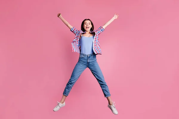 Full längd kroppsstorlek Visa foto attraktiv vänlig dam ledig tid nöjd positiv glad spänning höja armarna händer skrika isolerade slitage rutig kläder moderna sneakers pastellfärgad bakgrund — Stockfoto