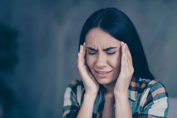 Close up photo beautiful she her lady arm temples eyes closed terrible suffer pain displeased hopeless worried wear checkered plaid shirt comfort flat house living room indoors — стоковое фото