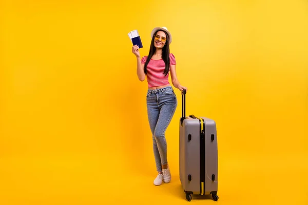 Full längd kroppsstorlek Visa foto av charmig trendig kvinna håll ahnd har Voyage Tour klädd denim jeans rödrandig t-shirt Känn dig glad isolerad gul bakgrund — Stockfoto