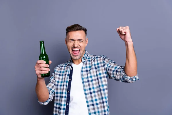 Retrato de su agradable atractivo alegre barbudo alegre con camisa a cuadros sosteniendo en la mano la luz de la cerveza soltero viendo espectáculo aislado sobre fondo azul gris — Foto de Stock