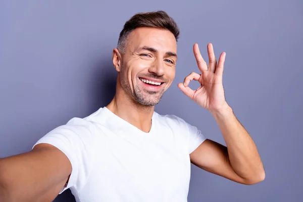 Zavřít fotografii úžasné, že jeho střední věk macho dokonalé vzezření je snadné, když se vám to zlíbí ruka paže setkáme symbol tónoty nosí příležitostné bílé tričko izolované šedé pozadí — Stock fotografie