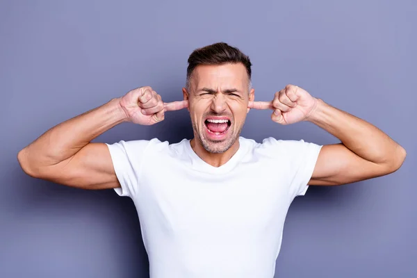 De cerca la foto asombroso él su mediana edad macho manos brazos ocultar oídos completo ira indignado rabia sonrisa dientes quejándose ruido ruidoso música vecinos usar casual blanco camiseta aislado gris fondo — Foto de Stock