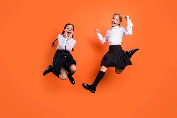 Plná délka těla, pohled na dvě osoby pěkná, okouzlující, veselá, veselá, předškolní dívky se zábavným novým akademickým rokem září a značkou izolovanou na zářivě svěží oranžové pozadí — Stock fotografie