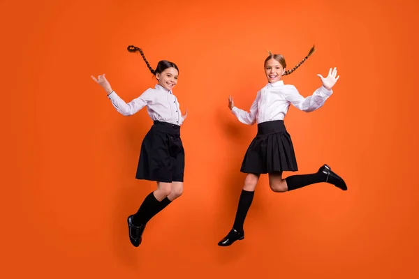 Comprimento total do corpo tamanho vista de duas pessoas agradável atraente bonito animado alegre alegre positivo pré-adolescente meninas se divertindo se alegrar Setembro isolado no brilhante brilho vívido fundo laranja — Fotografia de Stock