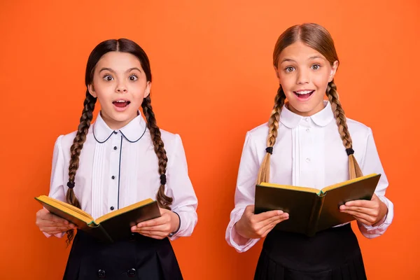 Porträtt av två personer trevlig attraktiv intagande härlig charmig söt glad munterhet pre-teen flickor läsa dagbok bok vetenskap matematik isolerade över ljusa levande glans orange bakgrund — Stockfoto