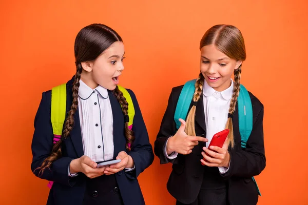 Close-up foto duas pessoas bonitas ela sua pequena senhora boca aberta mãos braços telefone leitor instagram seguidores usam formalwear camisa blazer saia escola forma saco isolado laranja brilhante fundo — Fotografia de Stock