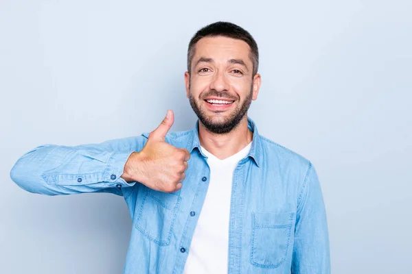 De cerca la foto increíble él su macho perfecto aspecto dientes blancos brazo de la mano levantó el pulgar hacia arriba símbolo aconsejando buena ropa de nuevo producto casual jeans camisa de mezclilla aislado fondo gris — Foto de Stock