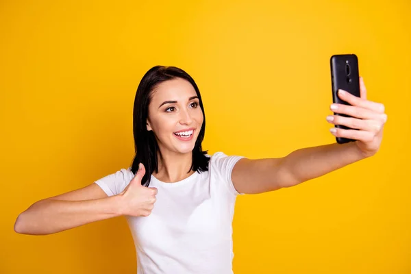 Close up φωτογραφία όμορφη καταπληκτική αυτή κυρία τηλέφωνο χέρι χεριού κάνει να πάρει selfie αντίχειρα πάνω σύμβολο ομιλία πω Skype γκόμενος φορούν περιστασιακή λευκό t-shirt τζιν απομονωμένο φωτεινό κίτρινο φόντο — Φωτογραφία Αρχείου