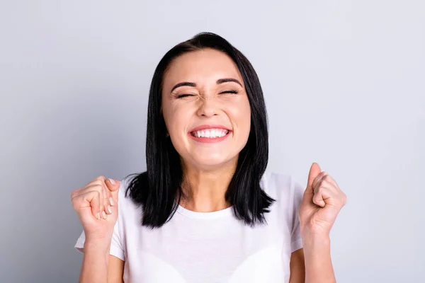 Close up foto bello incredibile lei la sua signora perfetto aspetto ideale migliore vincere alzato pugni occhi chiusi celebrare concorso cheerleader indossare casual bianco t-shirt isolato luminoso grigio sfondo — Foto Stock