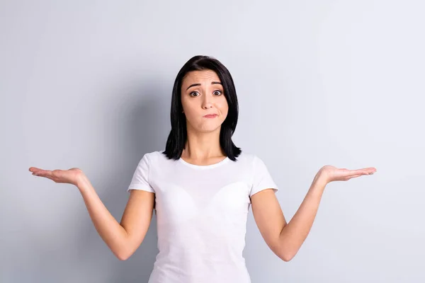 Retrato de ella ella bonita atractiva chica confusa insegura incierto atractivo sosteniendo dos objetos en las palmas copia vacío espacio en blanco anuncio publicitario no sé aislado sobre fondo pastel gris claro — Foto de Stock