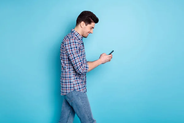 Foto porträtt av vårdslös positiv optimistisk stilig tusenåriga Holding använda telefon samtidigt ha en promenad isolerad pastell bakgrund — Stockfoto