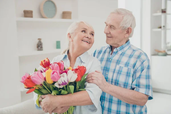 Retrato de ella ella su él dos agradable atractivo alegre alegre alegre tierna gente abuela sosteniendo en las manos grandes tulipanes naturales frescos felicitaciones primavera en blanco claro interior sala de estar —  Fotos de Stock