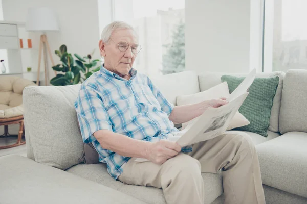 Portrét jeho jediného hezkého soustředěný poklidný klidný děda, sedící na Divan, četl svět novinové noviny ve světle bílém interiérovém domě v obývacím pokoji — Stock fotografie