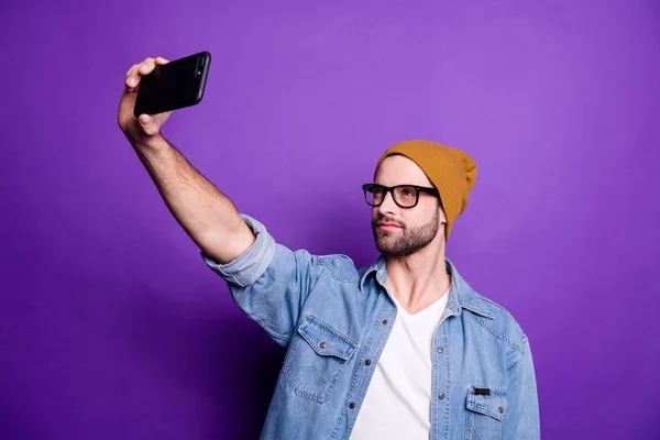 Zdjęcie cool facet trzyma telefon biorąc selfie na Instagram blog nosić denim strój na białym tle — Zdjęcie stockowe