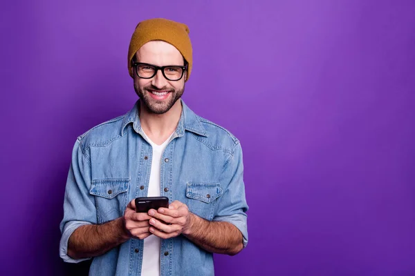 Cool beau gars tenant téléphone écriture amis casual tenue denim isolé fond violet — Photo