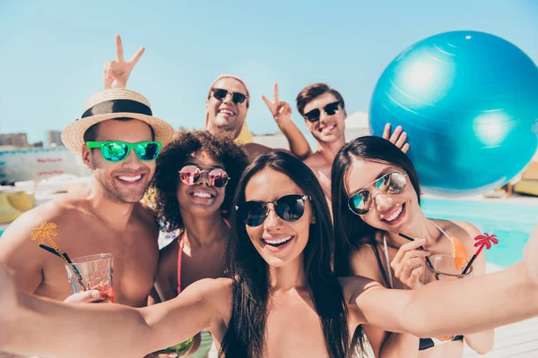 Photo rapprochée d'étudiants drôles mignons avec des cheveux bruns portant des lunettes de vue tenant un ballon faisant des photos moments v-signes sur le voyage à l'extérieur — Photo