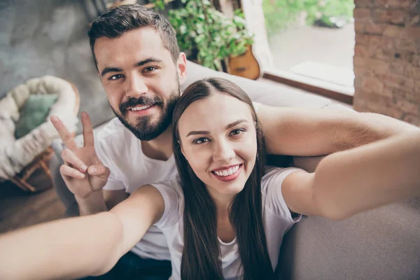 Foto de perfeito apenas casado par no amor passar lua de mel fazendo selfies sentado sofá dentro de casa — Fotografia de Stock