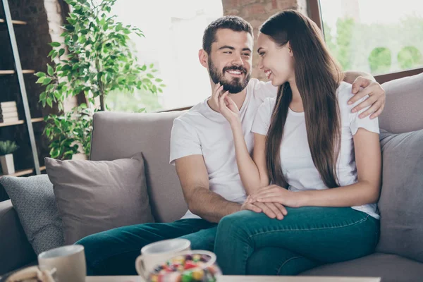 Foto de par satisfecho sentir emociones dulces sentados uno al lado del otro sofá en el interior — Foto de Stock