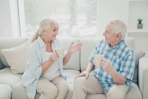 Retrato dela ela seu ele dois agradável atraente alegre cônjuges alegres amigáveis discutir notícias se divertindo de manhã na luz branca interior sala de estar dentro de casa — Fotografia de Stock