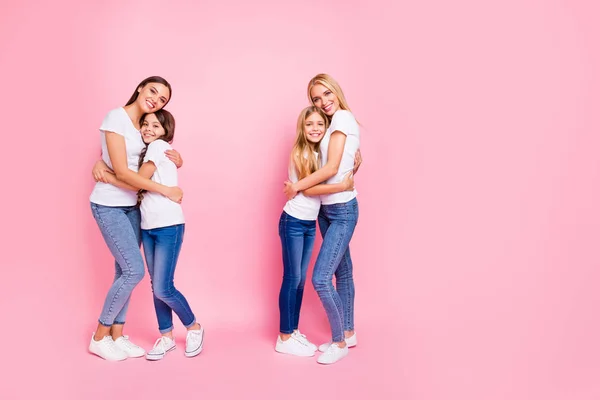 Foto de tamaño completo de cuatro señoras de diferentes edades abrazando overjoyed desgaste traje casual aislado fondo rosa —  Fotos de Stock