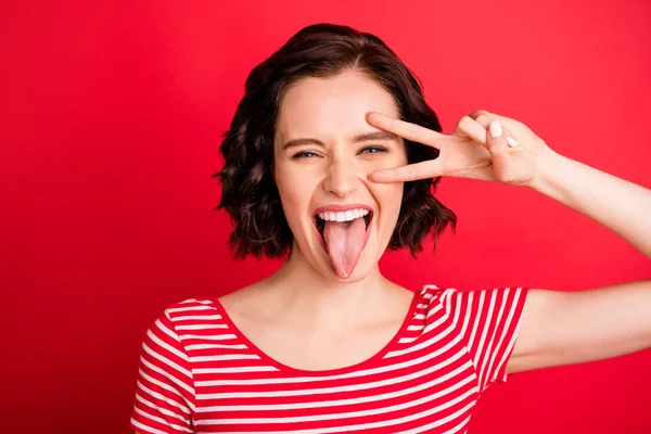 Foto de menina gritando mostrando sua língua depois de ter comido molho picante enquanto isolado com fundo vermelho — Fotografia de Stock