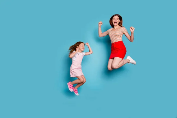 여우 작은 아가씨와 그녀의 흥분 된 엄마 점프 높은 착용 캐주얼 옷 고립 된 파란색 배경의 전체 크기 사진 — 스톡 사진