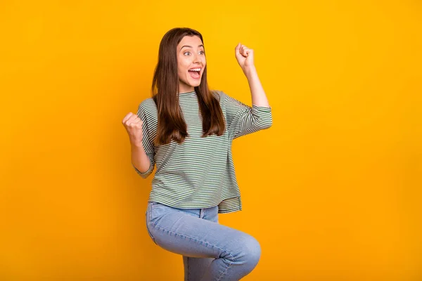 Photo of positively astonished woman wearing jeans denim trousers having learned of her victory in some competition and of sales at her favorite shop while isolated with yellow background — Stock Photo, Image