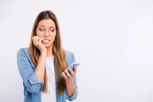 Крупным планом фото напуганной разочарованной женщины с телефоном в руке, смотрящей на экран изолированного серого фона — стоковое фото
